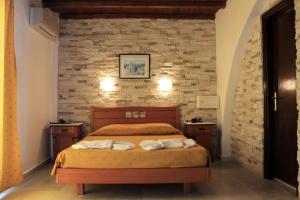 纳克索乔拉纳克索斯假日酒店的一间卧室设有一张床和砖墙