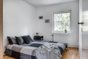 乌普萨拉Uppsala Large family home beside forest的白色的卧室设有床和窗户