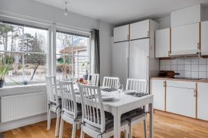 乌普萨拉Uppsala Large family home beside forest的厨房配有白色的桌椅和窗户。