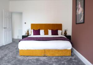 纳尔斯伯勒Berry's Loft - Central Location and Fast WIFI的一间卧室配有一张带紫色枕头的大床