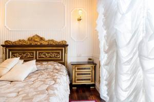 拉默齐亚泰尔默B&Boutique Lamezia Terme的一间卧室配有一张床和一个带白色床罩的床头柜。