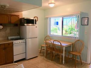 雷丁顿海岸Carousel Motel -Redington Shores的厨房配有桌子和白色冰箱。