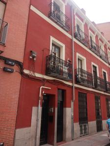 马德里Habitación en Madrid的街道上带阳台的红色建筑