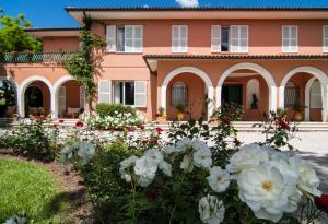 MonteluponeVILLA GARULLI的前面有白色花的粉红色房子
