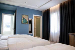 斯库台布里尼酒店的一间卧室设有两张床和蓝色的墙壁