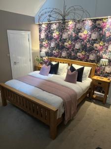 拉辛赫Wild Atlantic Lodge Bed & Breakfast的一间卧室设有一张带花卉墙壁的大床