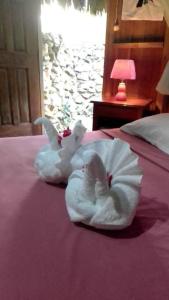 蓬塔戈尔达Sun Creek Lodge的一只白毛巾动物坐在床上