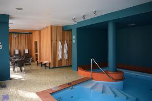 尤尔马拉Amber Sea Hotel & SPA的一个带桌椅的房间的游泳池