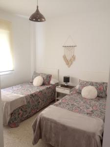 圣胡安德尔普埃尔托Casa Luz y Azahar的一间卧室配有两张床和一张带台灯的桌子