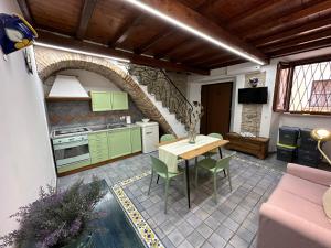 泰拉奇纳Casa Rappini的厨房配有绿色橱柜和桌椅