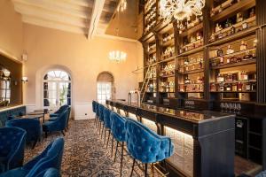 莱索里涅尔L'Abbaye De Villeneuve的一间酒吧,餐厅里摆放着蓝色的椅子