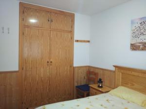 陶尔Apartamento con terraza y vistas panorámicas en Taüll的一间卧室配有木制橱柜和一张床