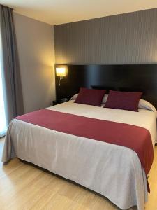 布拉内斯珀蒂帕劳酒店 - 仅限成年人的酒店客房配有一张带红色枕头的大床