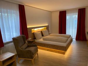 Schönwald普洛斯酒店的一间卧室配有一张床和一把椅子