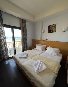 马萨阿拉姆sea view house的卧室配有一张带白色床单的大床和窗户。
