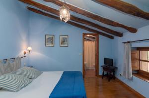 特雷斯诺卡索纳德拉萨尔塞达酒店的一间蓝色卧室,配有一张床和电视