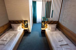 里马夫斯卡索博塔Hotel Carrera的两张位于酒店客房内的单人床