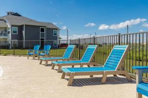 科珀斯克里斯蒂Peaceful Seaside Condo-Walking Path to the Beach的栅栏前的一排蓝色躺椅