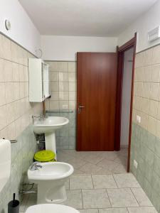 奇亚L'Oasi di Chia的一间带水槽、卫生间和门的浴室