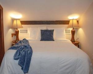 新奥尔良让拉菲特公寓式酒店的一间卧室配有一张带两盏灯的大型白色床。