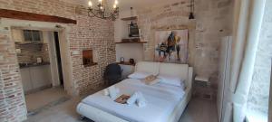 特罗吉尔Studios Kadena Trogir - 18th century stone house的一间砖墙内白色床的卧室