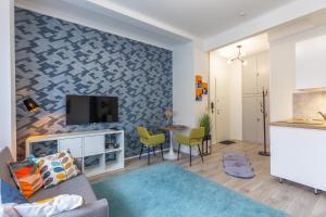 布达佩斯ALLEE BUDA Apartment的客厅配有沙发和墙上的电视