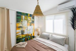 波利斯Akamas Sunset Boho Chic Maisonette by ONE VILLAS的一间卧室配有一张壁画床