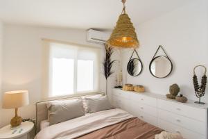 波利斯Akamas Sunset Boho Chic Maisonette by ONE VILLAS的一间卧室设有一张床和一个窗口