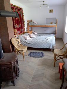 Wólka NadbużnaSołtysówka的一间小卧室,配有一张床和两把椅子