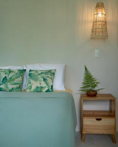 SavegreCasa Alba - Portasol Vacation的卧室配有一张床,在床头柜上种植植物