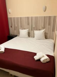 戛纳Arcotel Cannes 4 minutes du Palais des Festivals - NEW MANAGEMENT NEW TEAM - OLD REVIEVV的一张带白色床单的床和两张毛巾