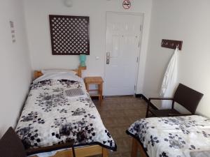 亚伊采TRIO sobe的一间卧室设有两张床、一张桌子和一扇门