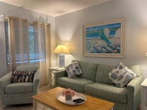 霍姆斯海滩An Island Getaway at Palm Tree Villas的客厅配有沙发和桌子
