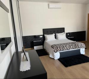托里迪蒙科尔武Casa da Tapada的一间卧室配有一张带黑白色棉被的床