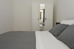 斯林Apartment Relax near Split with Jacuzzi的卧室配有白色的床和镜子