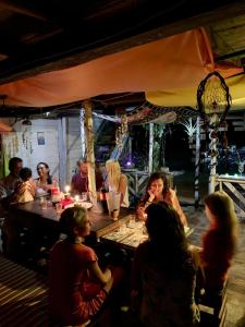 布兰卡滩DespertArte espacio de Arte y Hospedaje的一群人坐在餐馆的桌子旁