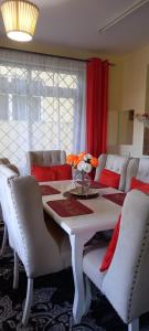 姆特瓦帕Stars Maisonette的一间配备有白色桌椅的用餐室