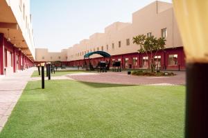 欧普尔فردان ريزيدانس - جدة Verdun Residence Jeddah的一座建筑前方的庭院,绿草成荫