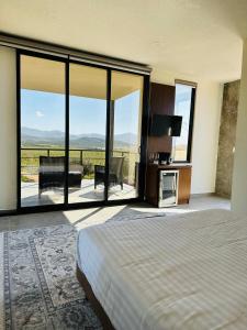 瓜达鲁佩镇Villa Sophia Valle de Guadalupe的一间卧室设有床铺和大型玻璃窗
