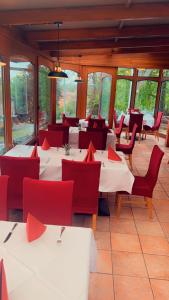 梅森希尔本奈申酒店的用餐室配有白色的桌子和红色的椅子