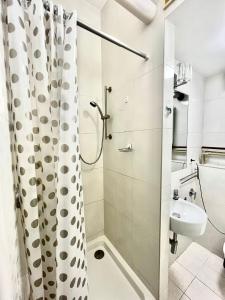 华沙Bezagenta Rooms Centrum的浴室配有淋浴帘和盥洗盆。