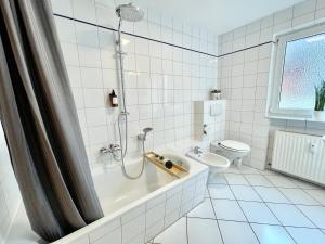 不莱梅Design Maisonette I Kamin I 10 Personen I Netflix的带淋浴和卫生间的白色瓷砖浴室