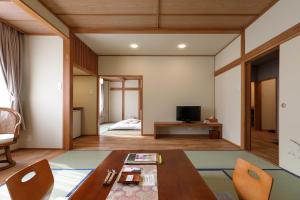 鹤冈市雅司旅馆的一间带桌子的客厅和一间卧室