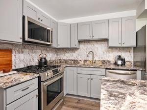 伯利恒Hyatus at City Views的白色的厨房,配有花岗岩台面和电器