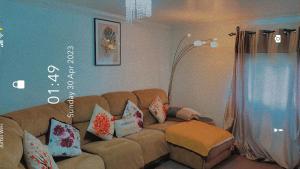 达格纳姆Lovely 2 Bed Flat/Apt in East London- Nice Estate.的客厅配有带枕头的棕色沙发