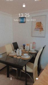 达格纳姆Lovely 2 Bed Flat/Apt in East London- Nice Estate.的餐桌,餐盘和椅子