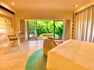 图卢姆Hotel Shibari - Restaurant & Cenote Club的一间卧室配有一张床、一张沙发和一张桌子