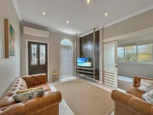 阿米代尔Bright 3-bedroom apartment - Central Armidale的客厅配有2张沙发和1台平面电视