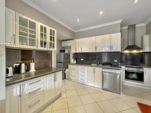 阿米代尔Bright 3-bedroom apartment - Central Armidale的厨房配有白色橱柜和不锈钢用具