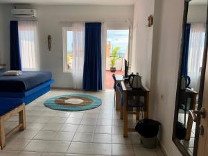 纳闽巴霍蔚蓝海洋酒店的一间卧室配有一张床、一张书桌和一个窗户。